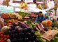 Maria dietro il suo banco di frutta e verdura al mercato Nomentano